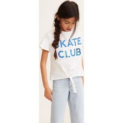 Mango Kids - Top dziecięcy Club 110-152 cm. Białe bluzki dziewczęce Mango Kids, z nadrukiem, z bawełny, z okrągłym kołnierzem, z krótkim rękawem, krótkie, bez kaptura. Za 49,90 zł.