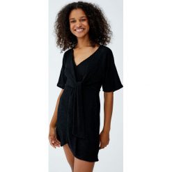 Sukienka z muślinu z węzłem. Czarne sukienki damskie Pull&Bear, bez wzorów, bez kołnierzyka, bez rękawów. Za 89,90 zł.