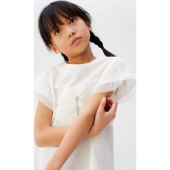 Mango Kids - T-shirt dziecięcy Butter 110-164 cm. Białe bluzki dziewczęce Mango Kids, z aplikacjami, z bawełny, z okrągłym kołnierzem, z krótkim rękawem, krótkie, bez kaptura. W wyprzedaży za 47,90 zł.
