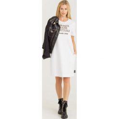 SUKIENKA VERSACE JEANS COUTURE. Białe sukienki damskie Versace Jeans Couture, na co dzień, s, z aplikacjami, z bawełny, z okrągłym kołnierzem, bez rękawów, proste. Za 909,00 zł.