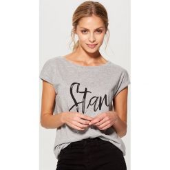 Koszulka z połyskującym napisem - Jasny szar. Szare t-shirty damskie marki Mohito, s, z napisami. W wyprzedaży za 14,99 zł.