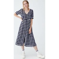Sukienka midi w kratkę z guzikami z przodu. Zielone sukienki damskie Pull&Bear, w kratkę, bez kołnierzyka, bez rękawów, midi. Za 139,00 zł.