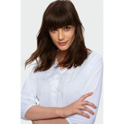 Elegancka biała bluzka. Białe bluzki damskie Greenpoint, bez wzorów, z bawełny, eleganckie, bez kołnierzyka, bez rękawów. Za 49,99 zł.