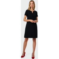 Sukienka o trapezowym kroju czarna - 38. Czarne sukienki damskie e-margeritka.pl, bez wzorów, z poliesteru, eleganckie, z krótkim rękawem, krótkie, bez kaptura. Za 129,99 zł.