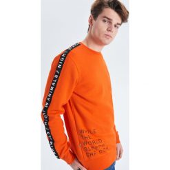 Pomarańczowa bluza z kolekcji Night Animals - Pomarańczowy. Pomarańczowe bluzy męskie Cropp, s, bez wzorów, bez kołnierzyka, bez rękawów, bez kaptura. W wyprzedaży za 49,99 zł.