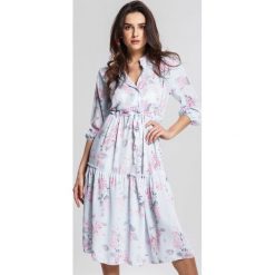Jasnoniebieska Sukienka Autarkic. Niebieskie sukienki damskie marki other, m, bez wzorów, eleganckie, bez kołnierzyka, bez rękawów, midi, kopertowe. Za 99,99 zł.