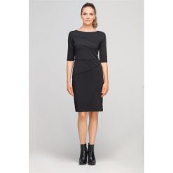 Dopasowana do sylwetki sukienka z ciekawymi, ukośnymi przeszyciami. Szare sukienki damskie Made in Poland, bez wzorów, z poliesteru, bez kołnierzyka, bez rękawów, dopasowane. Za 189,00 zł.