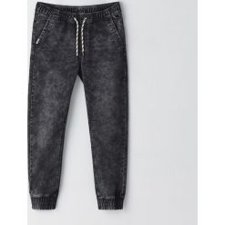 Joggery z przetarciami -. Spodnie męskie Cropp, bez wzorów, z jeansu. Za 119,99 zł.