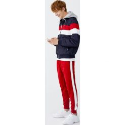 Spodnie jogging z lampasami i mankietami. Czarne spodnie męskie marki Pull&Bear, m, bez wzorów, z dzianiny. Za 89,90 zł.
