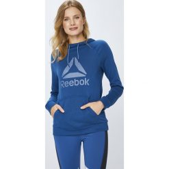 Reebok - Bluza. Niebieskie bluzy damskie z kieszeniami marki Reebok, s, z nadrukiem, z bawełny, z kapturem. W wyprzedaży za 199,90 zł.