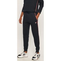 Tommy Sport - Spodnie. Niebieskie spodnie męskie Tommy Sport, s, z nadrukiem, z bawełny, sportowe. Za 399,90 zł.