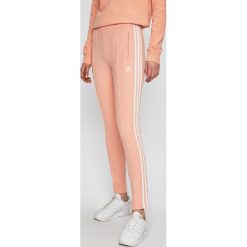 Adidas Originals - Spodnie. Pomarańczowe spodnie damskie adidas Originals, z elastanu. W wyprzedaży za 219,90 zł.