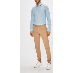 Lacoste - Spodnie. Pomarańczowe chinosy męskie marki Lacoste, z elastanu. W wyprzedaży za 299,90 zł.