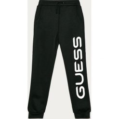 Guess Jeans - Spodnie dziecięce 116-175 cm. Różowe spodnie dziewczęce Guess Jeans, z nadrukiem, z bawełny. Za 179,90 zł.