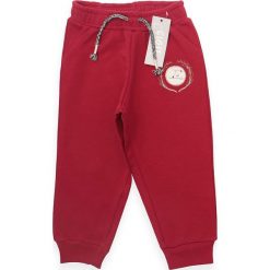 Spodnie dresowe w kolorze czerwonym. Czerwone spodnie niemowlęce Daisy, z aplikacjami, z dresówki. W wyprzedaży za 47,95 zł.