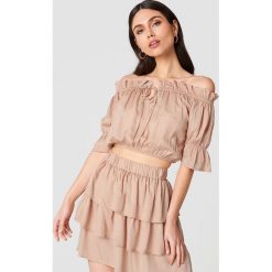 Linn Ahlborg x NA-KD Krótki top Singoalla - Nude. Szare topy damskie Linn Ahlborg x NA-KD, bez wzorów, z falbankami. W wyprzedaży za 50,47 zł.