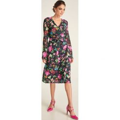 Sukienka w kolorze czarnym ze wzorem. Czarne sukienki damskie Heine, bez wzorów, bez kołnierzyka, bez rękawów, midi, rozkloszowane. W wyprzedaży za 175,95 zł.