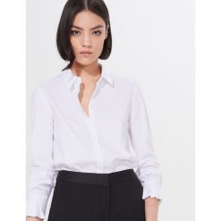 Klasyczna koszula z bawełną -. Koszule damskie Mohito, bez wzorów, z bawełny, klasyczne, z klasycznym kołnierzykiem, bez rękawów. Za 119,99 zł.