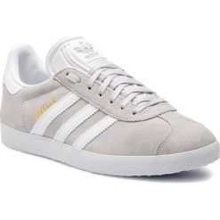 Buty adidas - Gazelle F34053 Greone/Ftwwht/Goldmt. Szare buty sportowe damskie Adidas, bez wzorów, ze skóry, eleganckie, bez obcasa, na płaskiej podeszwie, bez zapięcia. W wyprzedaży za 279,00 zł.