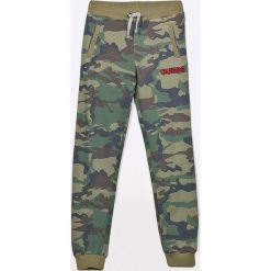 Guess Jeans - Spodnie dziecięce 118-175 cm. Szare spodnie chłopięce Guess Jeans, z aplikacjami, z bawełny, sportowe. W wyprzedaży za 139,90 zł.