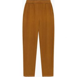 Lniane spodnie "Ficobay" w kolorze jasnobrązowym. Pomarańczowe spodnie damskie American Vintage, s, ze lnu. W wyprzedaży za 214,95 zł.