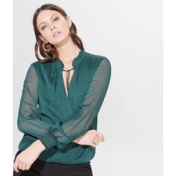 Szyfonowa bluzka z wiązaniem - Khaki. Brązowe bluzki damskie Mohito, bez wzorów, z szyfonu, bez kołnierzyka, bez rękawów. W wyprzedaży za 59,99 zł.