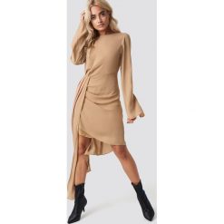 NA-KD Party Sukienka z drapowanym detalem - Beige. Brązowe sukienki asymetryczne marki NA-KD Party, na imprezę, z tkaniny, z asymetrycznym kołnierzem, midi. Za 202,95 zł.