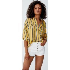 Luźna koszula basic z nadrukiem. Pomarańczowe koszule damskie Pull&Bear, z nadrukiem, bez kołnierzyka, z krótkim rękawem. Za 59,90 zł.