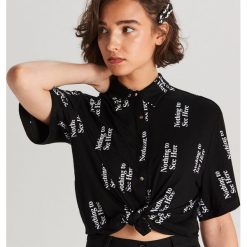 Koszula oversize z napisami - Czarny. Czarne koszule damskie Cropp, xs, z napisami, bez kołnierzyka, bez rękawów. W wyprzedaży za 39,99 zł.