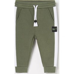 Joggery z kontrastowymi lampasami - Khaki. Brązowe spodnie męskie Reserved, bez wzorów. Za 45,99 zł.