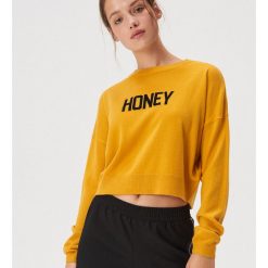Krótki sweter z hasłem - Żółty. Żółte swetry damskie Sinsay, m, bez wzorów, z krótkim rękawem, krótkie, bez kaptura. W wyprzedaży za 29,99 zł.