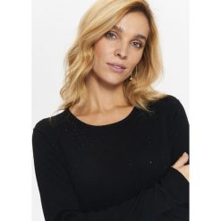 SWETER Z OZDOBNYMI KAMYCZKAMI Z PRZODU. Czarne swetry klasyczne damskie marki Top Secret, na zimę, z okrągłym kołnierzem. W wyprzedaży za 39,99 zł.