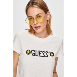 Guess Jeans - Top. Białe topy damskie Guess Jeans, s, z nadrukiem, z bawełny, z okrągłym kołnierzem. W wyprzedaży za 149,90 zł.