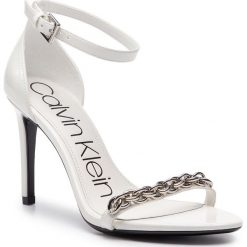 Sandały CALVIN KLEIN - Rajni E8858 White. Białe klapki damskie Calvin Klein, bez wzorów, ze skóry ekologicznej, bez obcasa, na obcasie. W wyprzedaży za 549,00 zł.