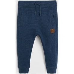 Mango Kids - Spodnie dziecięce Minioto 80-104 cm. Niebieskie spodnie chłopięce Mango Kids, bez wzorów, z bawełny, casualowe. Za 45,90 zł.