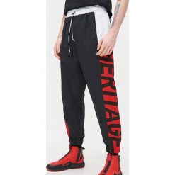 Joggery z dwukolorowym lampasem - Czerwony. Czerwone spodnie męskie Cropp, m. Za 119,99 zł.