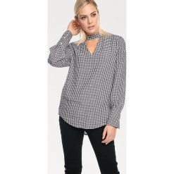 Bluzka w kolorze czarno-białym. Czarne bluzki damskie Heine, w kratkę, ze stójką, bez rękawów. W wyprzedaży za 79,95 zł.