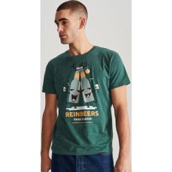 T-shirt ze świątecznym nadrukiem - Turkusowy. Niebieskie t-shirty męskie Reserved, s, z nadrukiem, wizytowe, bez kołnierzyka. Za 29,99 zł.