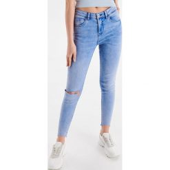 Jeansy Skinny z przetarciami - Niebieski. Niebieskie jeansy damskie Cropp. W wyprzedaży za 39,99 zł.