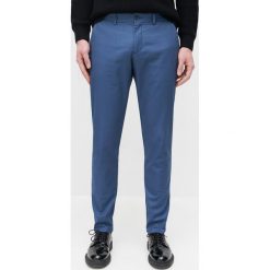 Bawełniane chinosy slim -. Spodnie męskie Reserved, bez wzorów, z bawełny. Za 129,99 zł.