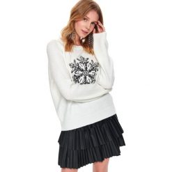 Sweter z błyszczącą aplikacją. Białe swetry damskie Top Secret, na zimę, z aplikacjami, z dzianiny, bez rękawów, bez kaptura. W wyprzedaży za 69,99 zł.