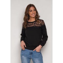 Bluza w kolorze czarnym. Czarne bluzy damskie s, w koronkowe wzory, z koronki. W wyprzedaży za 99,95 zł.