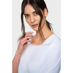 Biała elegancka bluzka z mereżką. Białe bluzki damskie Greenpoint, bez wzorów, z poliesteru, eleganckie, bez kołnierzyka, bez rękawów. Za 29,99 zł.