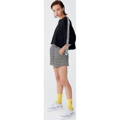 Sportowa koszulka z taśmami. Czarne bluzki sportowe damskie Pull&Bear, bez wzorów, bez kołnierzyka, z krótkim rękawem, krótkie, bez kaptura. Za 69,90 zł.