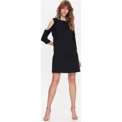 Sukienka dzianinowa 'cold shoulder'. Czarne sukienki damskie Top Secret, na co dzień, na zimę, bez wzorów, z dzianiny, eleganckie, z falbankami, bez rękawów. W wyprzedaży za 34,99 zł.