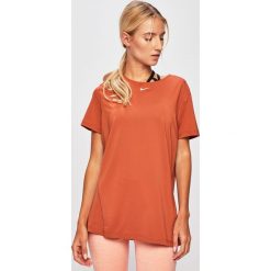 Nike - T-shirt. Pomarańczowe topy damskie Nike, s, bez wzorów, z elastanu, z okrągłym kołnierzem. W wyprzedaży za 99,90 zł.
