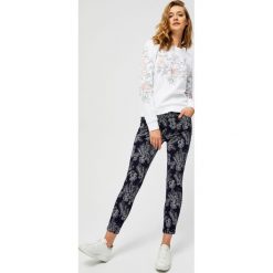 Spodnie w kwiaty. Niebieskie spodnie damskie Moodo, xs, z nadrukiem, z elastanu. Za 29,99 zł.