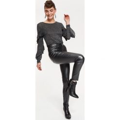 Dopasowana błyszcząca bluzka z falbanami. Szare bluzki damskie Top Secret, bez wzorów, z dzianiny, eleganckie, z dekoltem w serek, bez rękawów. W wyprzedaży za 24,99 zł.