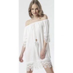 Biała Sukienka Rhaeneira. Białe sukienki damskie Born2be, na imprezę, s, w koronkowe wzory, z koronki, boho, bez kołnierzyka, z długim rękawem, długie, mini, trapezowe. Za 69,99 zł.