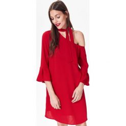 Asymetryczna sukienka damska z wiązaniem na szyji. Czerwone sukienki damskie Top Secret, na zimę, bez wzorów, eleganckie, z falbankami, bez rękawów, asymetryczne. W wyprzedaży za 59,99 zł.